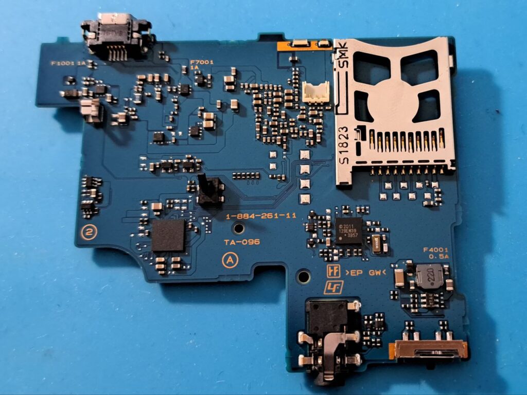 Die Vorderseite eines PSP-Motherboards auf blauem Untergrund.