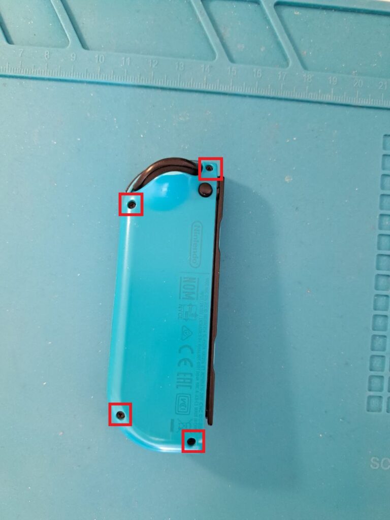 blauer Joy-Con auf blauem Hintergrund. Die Schrauben auf der Rückseite sind markiert